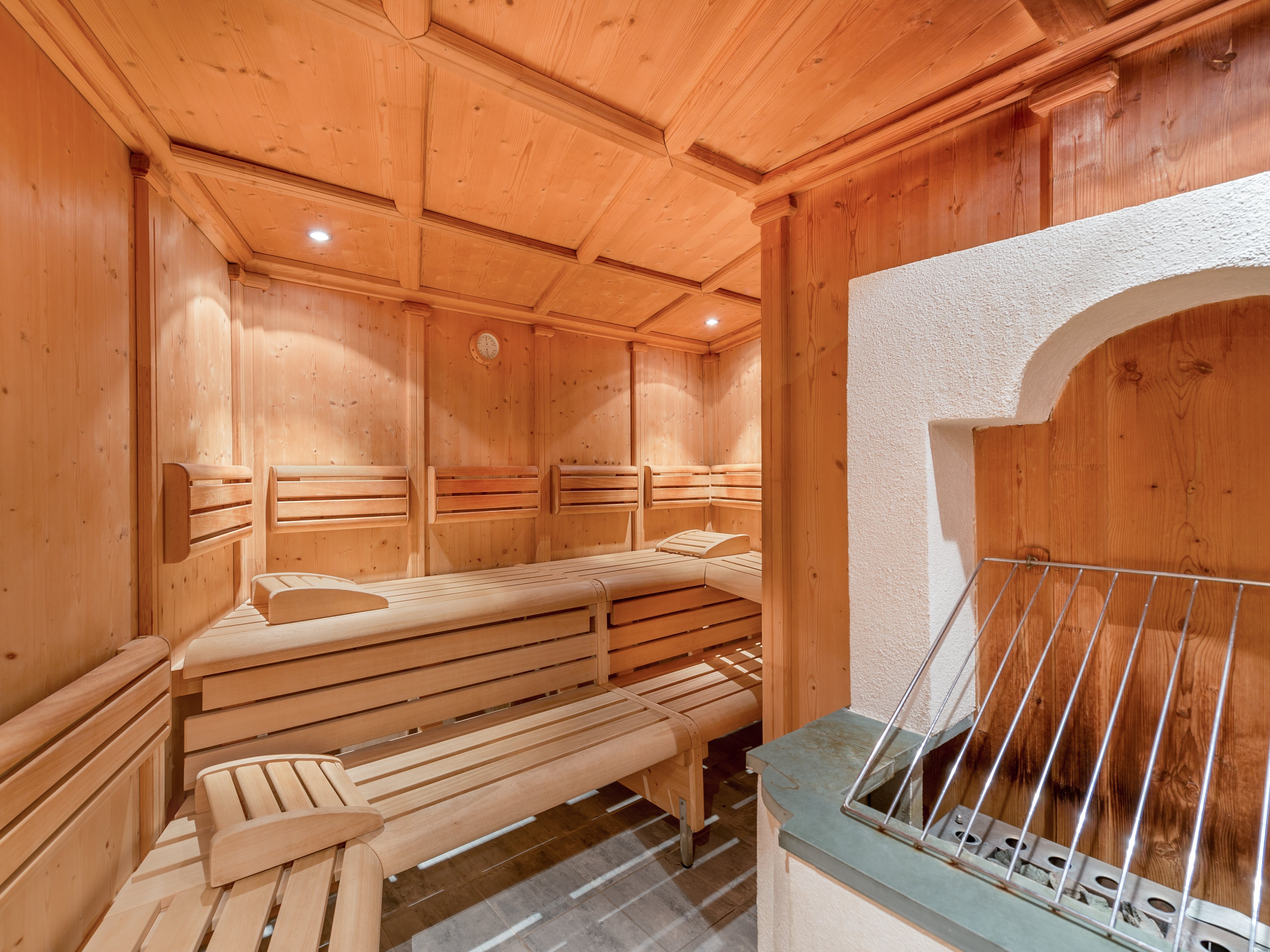 Holzsauna für Entspannung Innenansicht einer Sauna mit Holzbänken und einem Heizgerät, die zum Relaxen einlädt.